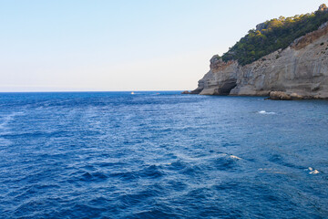 Fototapeta premium View of the rocky shore from the sea. Mediterranean Sea in Turkey. Popular tourist places. Background