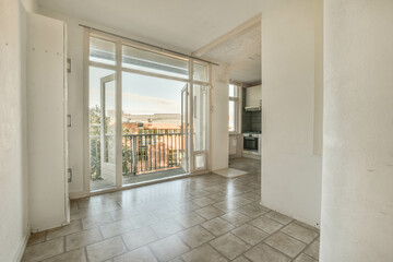 an empty living room with sliding glass doors that open to the balcony and view of the city outside...