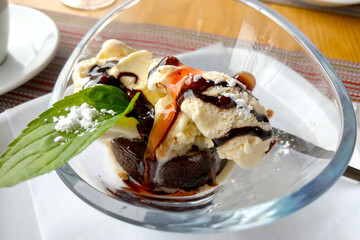 Glass plate with ice cream and chocolate with mint.
