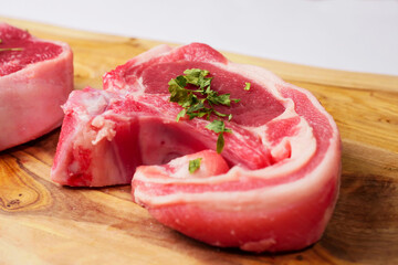 Fresh lamb loin chop with herb on a wooden cutting board. Meat industry product. Butcher craft.