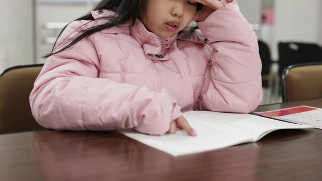 図書館で漢字を勉強している小学生の女の子の様子