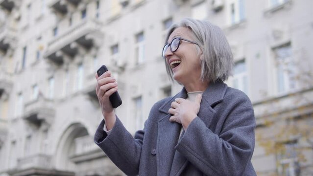 Mature lady checking balance on smartphone and rejoicing, received a pay raise
