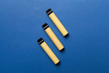 Disposable electronic cigarettes on color background, top view
