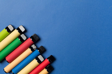 Disposable electronic cigarettes on color background, top view