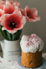 Easter cake Panettone close up photo. Pink tulips spring flowers close up