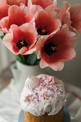 Easter cake Panettone close up photo. Pink tulips spring flowers close up