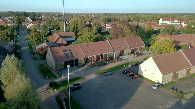 Barn Quarter  kremmen. Modern converted barns in Brandenburg. Tranquil aerial view flight raise up drone
golden houre 2022. 4k marnitz Cinematic