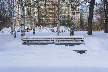 Bench under snow in the city park in winter day