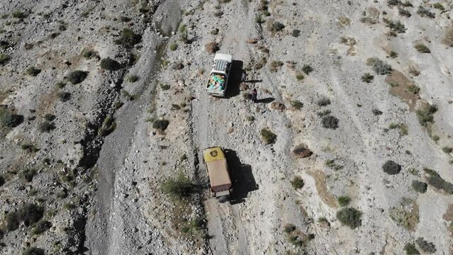Aerial top shot of 2 car driving in the mountain road in the morning time. 