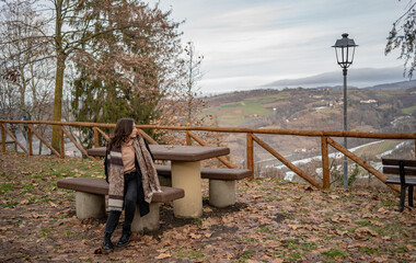 Girl is sitting on the bench in La Chiesa Parrocchiale di San Lorenzo a Tremezzo, Lago di Como, Italia, winter time