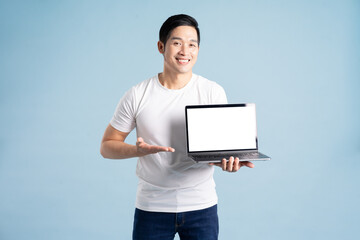 portrait of asian man posing on blue background