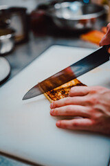 chef hands cutting toast on a kitchen board.