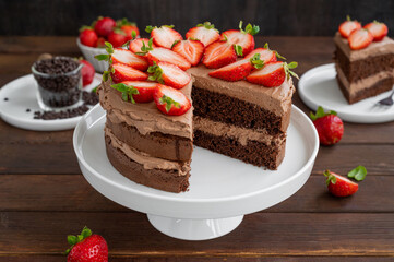 Naked chocolate cake with cream and fresh strawberries on top. Rustic style. Selective focus. Copy space.