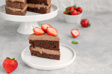 Naked chocolate cake with cream and fresh strawberries on top. Rustic style. Selective focus. Copy space.
