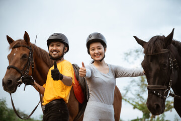 two equestrian athletes ride horses and start training in outdoor background