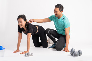 Obraz premium woman with basic push up movement with trainer holding back on white background