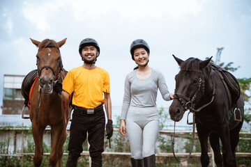two equestrian athletes ride horses and start training in outdoor background