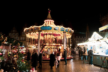 The Old City of Bremen during the holidays season, Christmas market in Bremen, Die Sögestrasse, street of Bremen with light reflexion after the rain, people in Xmas Market - obrazy, fototapety, plakaty
