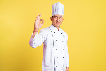 asian male chef smiling with okay hand gesture on isolated background