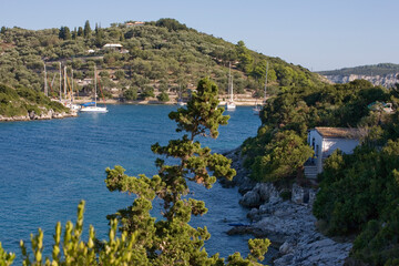 The beautiful bay of Moggonissi, at the southern tip of Paxos, Greece, with a small fleet of moored yachts anchored in the sheltered harbour