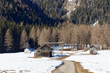 Old wooden huts in a mountain forest in late winter, Alps, Europe