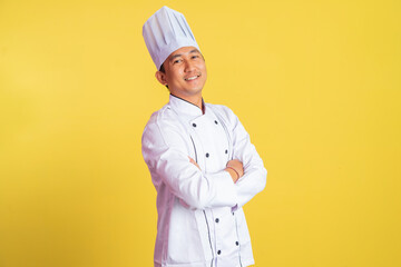 asian male chef smiling with hands crossed on isolated background
