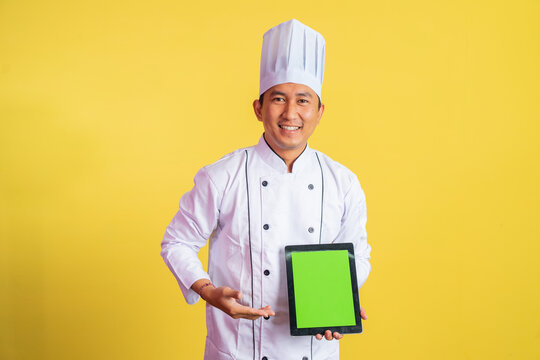 Male Chef Wearing Chef Jacket Showing Blank Tablet Screen On Isolated Background