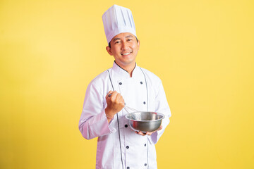 asian male chef smiling while using whisk with mixing bowl on isolated background