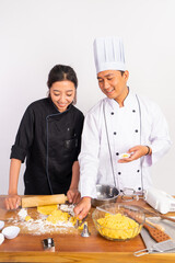 male and female chefs making cookie dough at the table on isolated background