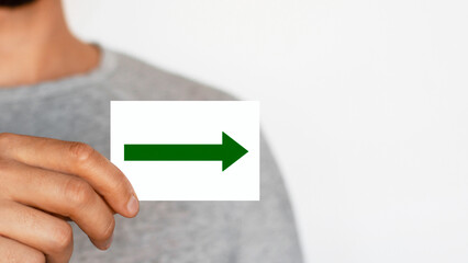 Man holding a right arrow sign. Green arrow pointing to the right. The male. Direction. Motion....