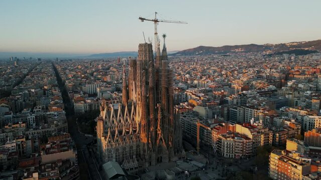 Temple Expiatori La Sagrada Familia in Barcelona, Catalonia, Spain. Drone Aerial Flying around the architectural masterpiece of Gaudi in the sunrise. High quality 4k footage