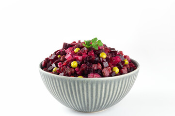 Traditional Russian vinaigrette salad on a white background. Salad of beets, potatoes, carrots and green peas. Christmas menu.