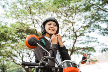 Fototapeta na wymiar Close up of high school girl wearing a helmet when going to ride a motorcycle