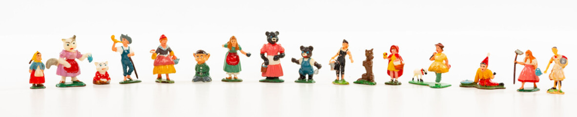Banner panorama row of small vintage toy people and characters isolated on white