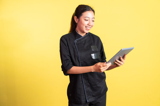 smiling asian female chef using digital tablet on isolated background