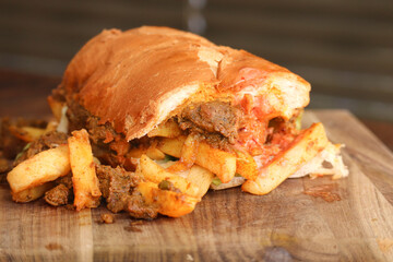 Masala steak Gatsby. Traditional South African fast food. Steak and hot chips on a large roll 