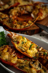 Lobster thermidor, a classic lobster dish in which a cooked lobster is halved down middle. The meat...