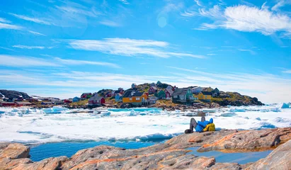 Fototapete Rund Panoramic view of colorful Kulusuk village in East Greenland - A Man Hiker looking at melting glacier - Melting of a iceberg and pouring water into the sea - Kulusuk, Greenland © muratart