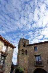 Fototapeta na wymiar Old Spanish village square with its stone tower on a sunny autumn day.