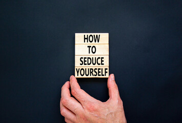 How to seduce yourself symbol. Concept word How to seduce yourself on wooden blocks. Businessman hand. Beautiful black table black background. Business and how to seduce yourself concept. Copy space.