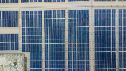 Fototapeta premium Aerial view of a solar panel photovoltaic with reflection on building roof top.