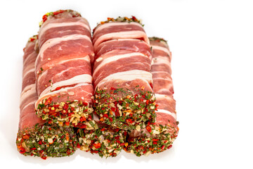 Bacon-wrapped meat roll with spices and herbs. Jamon pork, prosciutto, meat products, tartare meat...