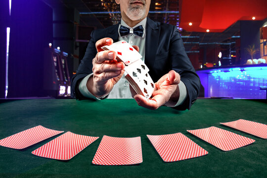 Croupier or casino dealer at gambling club or casino. Close up of male hand. Gambling concept