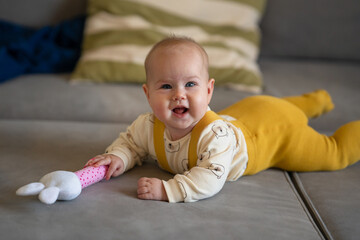 Cute happy baby crawling on the sofa in the living room