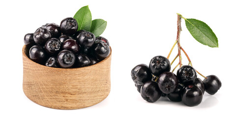 Chokeberry with leaf in wooden bowl isolated on white background. Black aronia berries