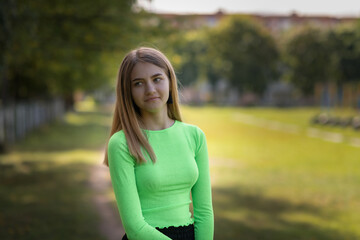 Portrait of a young beautiful fair-haired girl in a summer park.