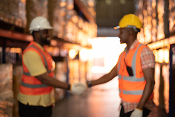 Blurry bokeh of teamwork of Black workers working in large warehouse store industry.Rack of stock storage.Interior of cargo in ecommerce and logistic concept. Depot. People lifestyle. Shipment service