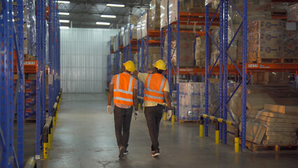 Fototapeta premium Teamwork of Black workers working in large warehouse store industry.Rack of stock storage. Interior of cargo in ecommerce and logistic concept. Depot. People lifestyle. Shipment service for container