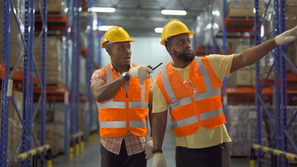 Teamwork of Black workers working in large warehouse store industry.Rack of stock storage. Interior of cargo in ecommerce and logistic concept. Depot. People lifestyle. Shipment service for container