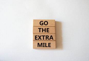 Go the extra mile symbol. Wooden blocks with words Go the extra mile. Beautiful white background. Business and Go the extra mile concept. Copy space.